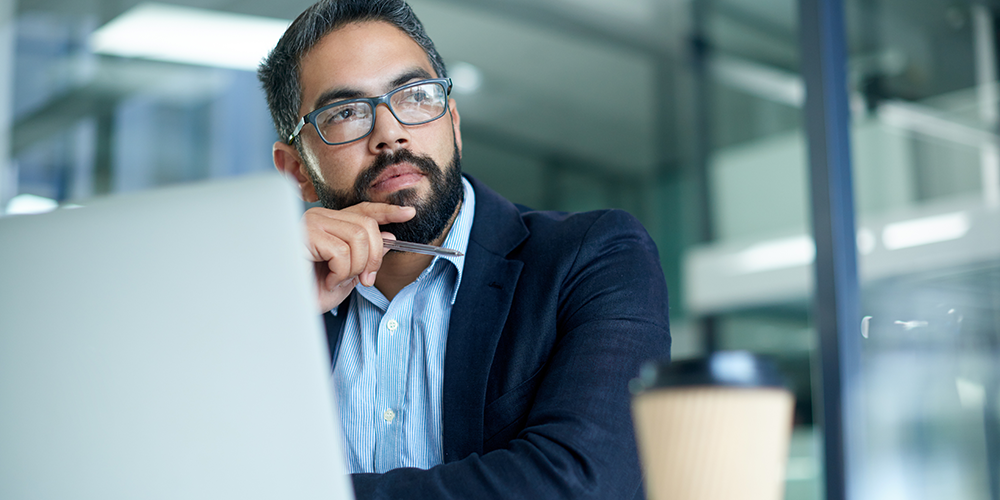 Man thinking in front of a laptop